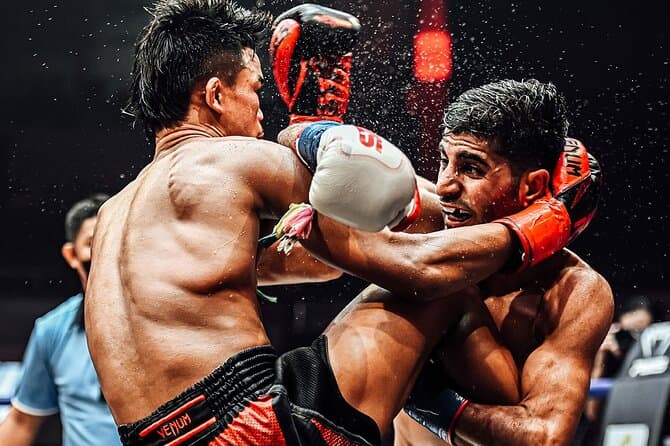 Échange violent au clinch pendant un combat de Muay Thaï