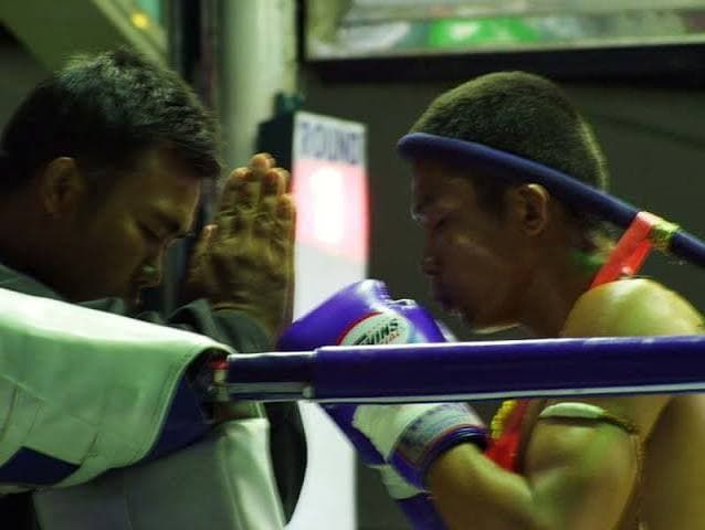 Moment de respect avant l'entrée en action sur un ring de Muay Thaï