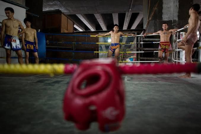 Salle de Muay Thaï : ring, casque et pratiquants